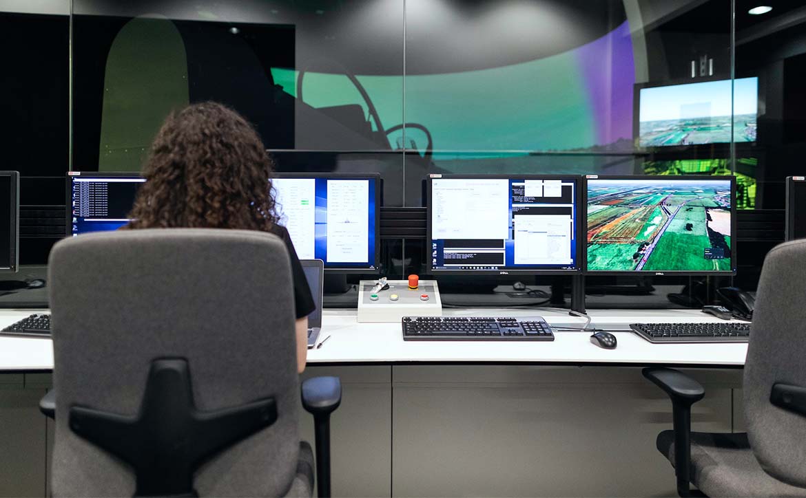 woman sitting in chair with computer and multiple monitors